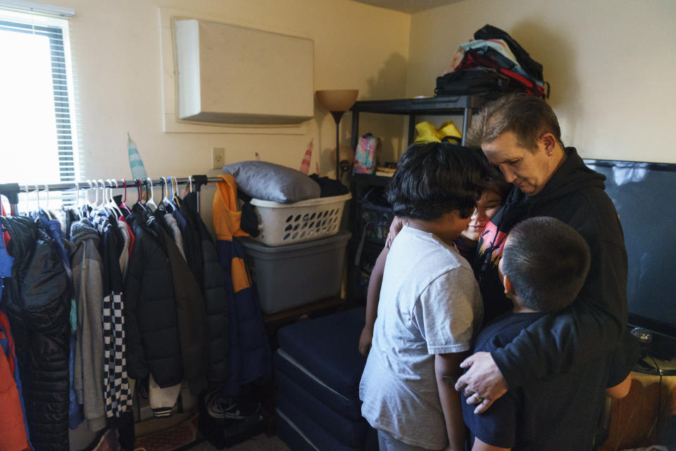 Greg Franson, right, embraces his nieces and nephew whom he's raising because their mother died of a methamphetamine overdose, as they stand in their apartment in Little Earth, a housing complex for Natives in Minneapolis, Monday, Nov. 15, 2021. Franson started a program to teach kids how drugs consumed their parents. "We don't want them to grow up and think, 'my mom never loved me. I'm unlovable. I'm worthless,'" he said. "That's a lot of hurt, guilt and shame, and it will just repeat this cycle." (AP Photo/David Goldman)