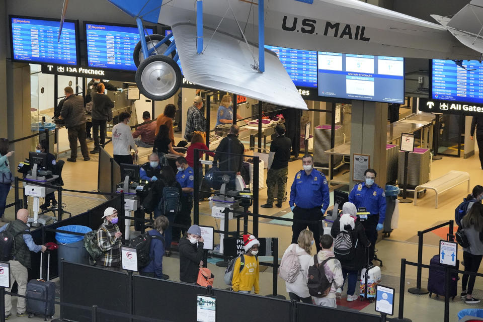 Holiday travelers line up at the security checkpoint check point at Pittsburgh International Airport in Imperial, Pa., Thursday, Dec. 23, 2021. At least three major airlines say they have canceled dozens of flights, Friday, Dec. 24, because illnesses largely tied to the omicron variant of COVID-19 have taken a toll on flight crew numbers during the busy holiday travel season. (AP Photo/Gene J. Puskar)