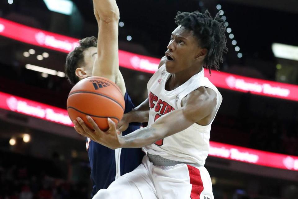N.C. State’s Terquavion Smith (0) drives to the basket past Virginia’s Francisco Caffaro (22) during the second half of N.C. State’s 77-63 victory over Virginia at PNC Arena in Raleigh, N.C., Saturday, Jan. 22, 2022.