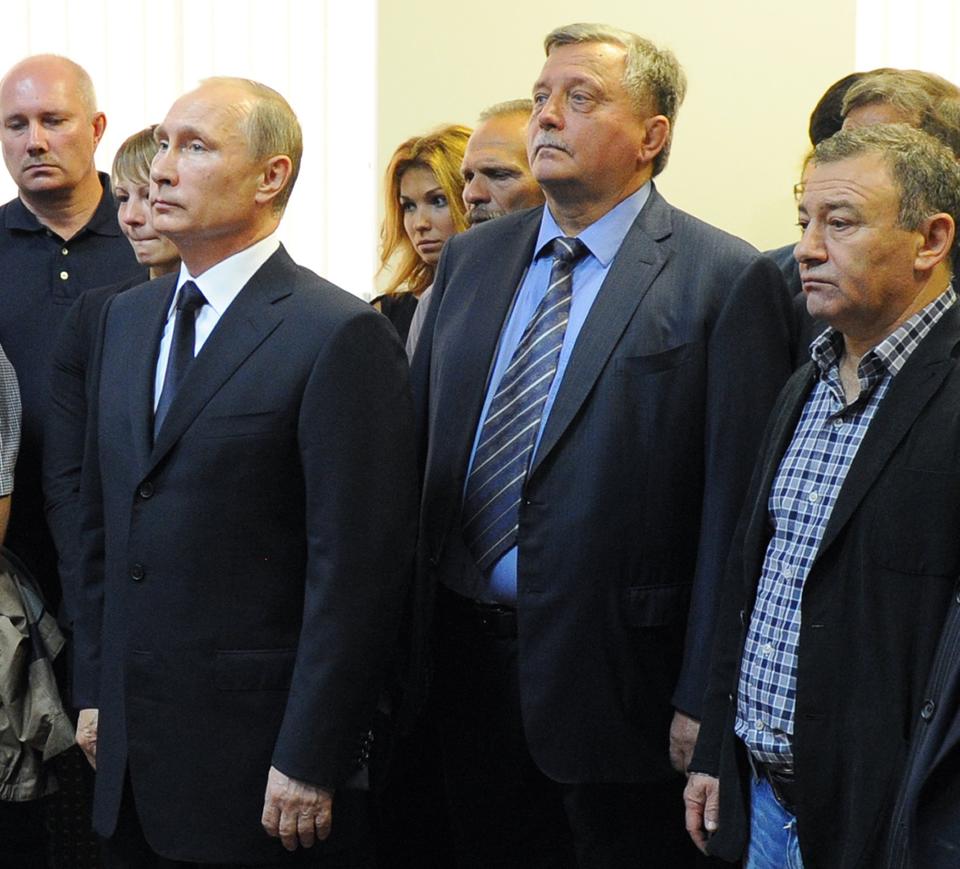 In this photo taken on Friday, Aug. 9, 2013, Russian President Vladimir Putin, left, and businessman and billionaire Arkady Rotenberg, right, mourn during the farewell ceremony of Putin's first judo coach, Anatoly Rakhlin in St. Petersburg, Russia. President Barack Obama on Thursday expanded U.S. economic sanctions against Moscow over its actions in Ukraine, targeting President Vladimir Putin's chief of staff and 19 other individuals as well as a Russian bank that provides them support. Those named in the sanctions Thursday, March 20, 2014, include Arkady Rotenberg lifelong Putin friend whose company has amassed billions of dollars in government contracts. (AP Photo/RIA-Novosti, Mikhail Klimentyev, Presidential Press Service)
