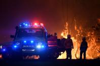 Los equipos del Servicio Rural de Bomberos de Nueva Gales del Sur protegen las propiedades de Waratah Road y Kelyknack Road cuando el incendio de Three Mile se aproxima a Mangrove Mountain, Australia