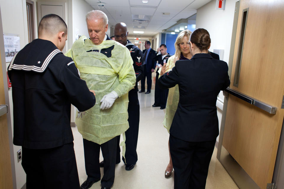 Navy corpsmen help Vice President Joe Biden and Dr. Jill Biden into gowns before meeting with patients and their families during a Christmas visit to Walter Reed National Military Medical Center in Bethesda, Md., Dec. 25, 2011. (Official White House Photo by David Lienemann)    This official White House photograph is being made available only for publication by news organizations and/or for personal use printing by the subject(s) of the photograph. The photograph may not be manipulated in any way and may not be used in commercial or political materials, advertisements, emails, products, promotions that in any way suggests approval or endorsement of the President, the First Family, or the White House.