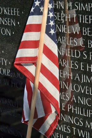 A U.S. flag rests at the base of the Vietnam Veteran's Memorial on Veteran's Day in Washington, in this November 11, 2006 file photo. REUTERS/Stelios Varias/Files