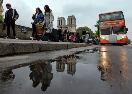 Tourists walk near Notre Dame Cathedral on the eve of the French presidential election in Paris, France, May 6, 2017. REUTERS/Jean-Paul Pelissier