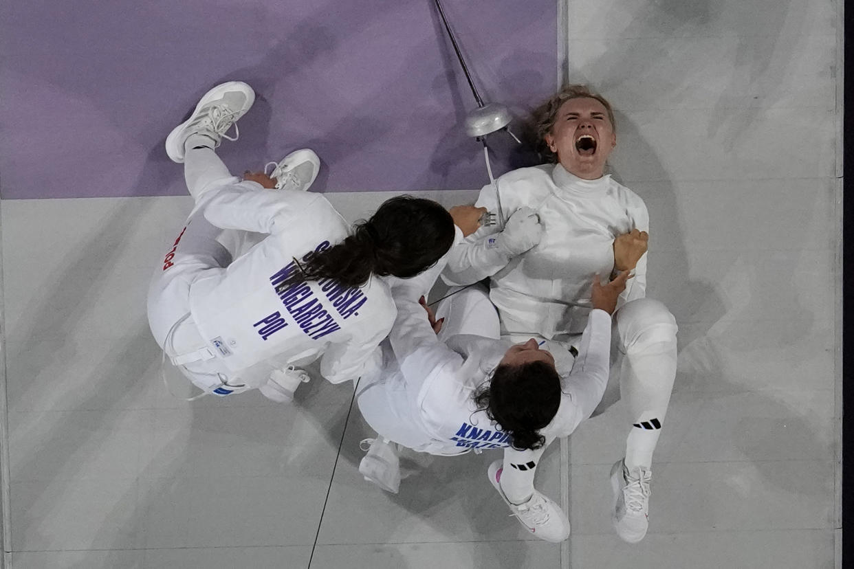 Poland's Aleksandra Jarecka, right, celebrates with teammates after winning the women's team Epee bronze final match against China's Yu Sihan at the 2024 Summer Olympics, Tuesday, July 30, 2024, in Paris, France. (AP Photo/Christophe Ena)