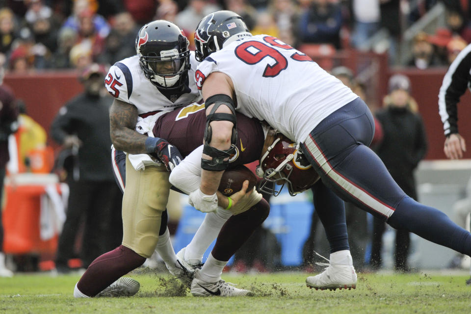 FILE - In this Nov. 18, 2018, file photo, Washington Redskins quarterback Alex Smith (11) injures his ankle as he is sacked by Houston Texans defensive end J.J. Watt (99) and Houston Texans strong safety Kareem Jackson (25) during the second half of an NFL football game, in Landover, Md. Alex Smith has finally shed the massive brace on his right leg eight months after breaking his tibia and fibula in gruesome fashion. Smith’s wife, Elizabeth, posted a photo Monday, July 15, 2019, of him holding the ring external fixator in his hand. (AP Photo/Mark Tenally, File)