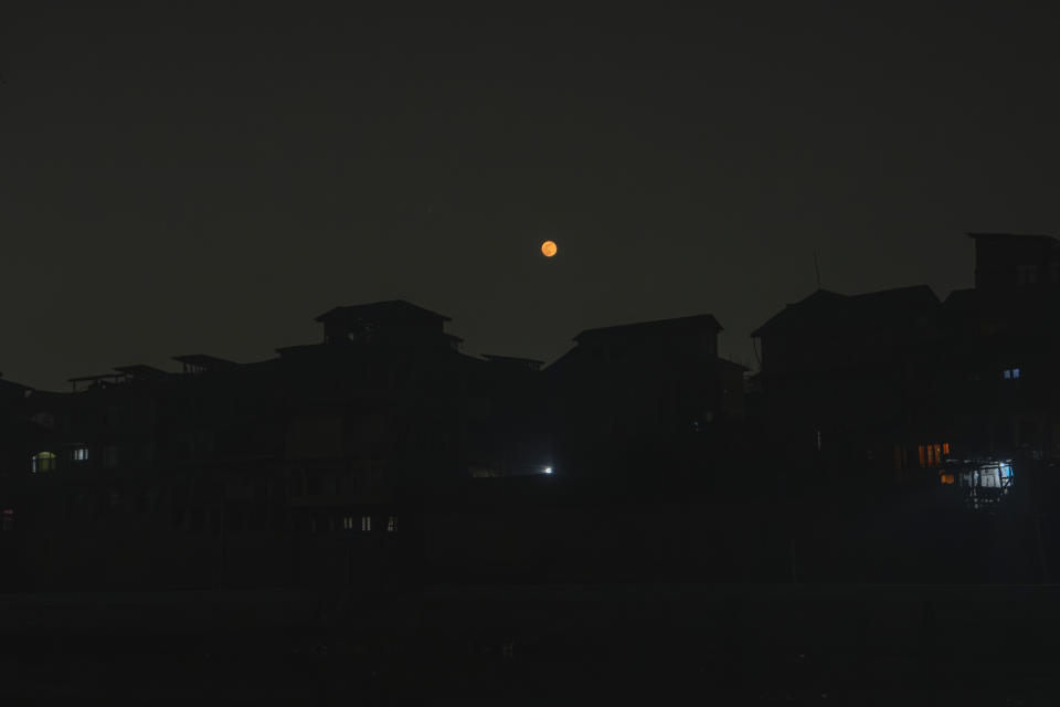 The moon rises during a power outage on a cold evening in Srinagar, Indian controlled Kashmir, Wednesday, Dec. 27, 2023. The subzero temperatures in Kashmir, a disputed region between India and Pakistan that has been marred by decades of conflict, also coincide with frequent power cuts. It is one of the idyllic valley's long-standing, unresolved crises. (AP Photo/Dar Yasin)