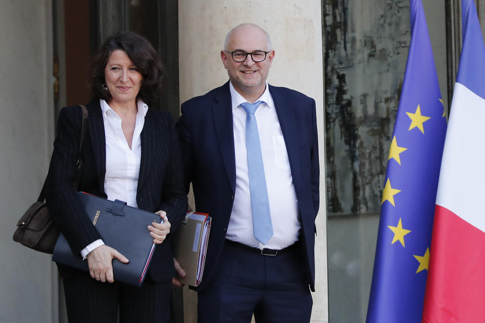 French Health Minister Agnes Buzyn, left, and newly appointed junior minister for pensions, Laurent Pietraszewski leave the Elysee Palace after the weekly cabinet meeting Wednesday, Dec.18, 2019 in Paris. With French President Emmanuel Macron under heavy pressure over his pension reform plans, government officials are meeting with employers and unions on Wednesday to consider the way forward. (AP Photo/Francois Mori)