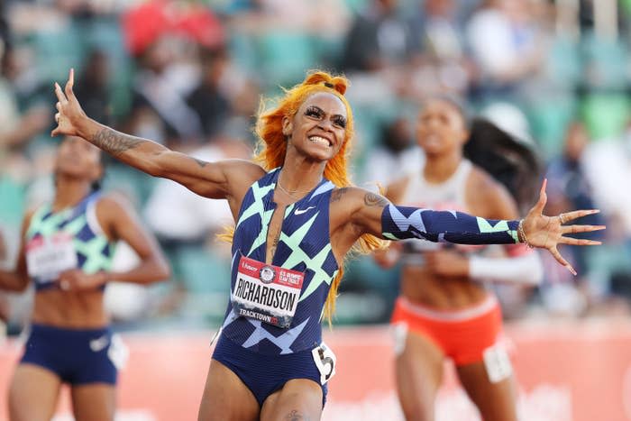 Sha'Carri, with arms raised and smiling, celebrates her performance in a race