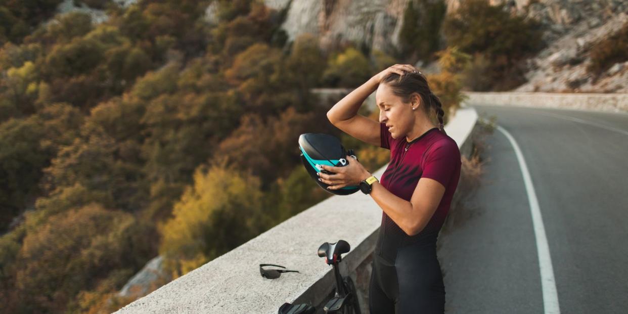 tired athlete woman after hard cycling training true emotions, professional sport riding a bicycle