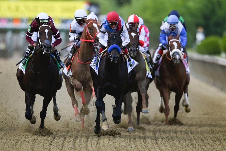 Medina Spirit (center) leads the pack during the 146th running of the Preakness Stakes at Pimlico Race Course.