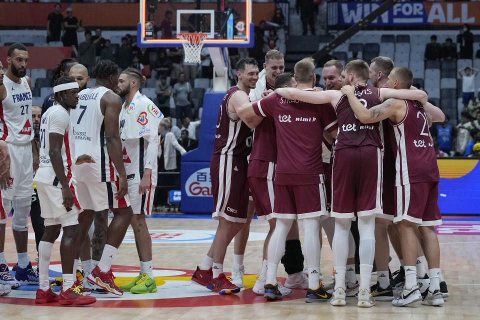 Latvia players huddle after defeating France in their Basketball World Cup group H match at the Indonesia Arena stadium in Jakarta, Indonesia, Sunday, Aug. 27, 2023. (AP Photo/Achmad Ibrahim)