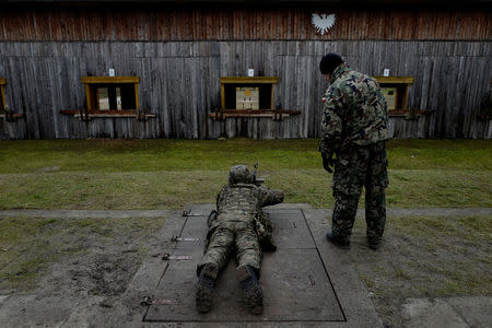A commander instructs a recruit during a 16-day basic training for Poland's Territorial Defence Forces, at a shooting range near Siedlce, Poland, December 7, 2017. REUTERS/Kacper Pempel/Files
