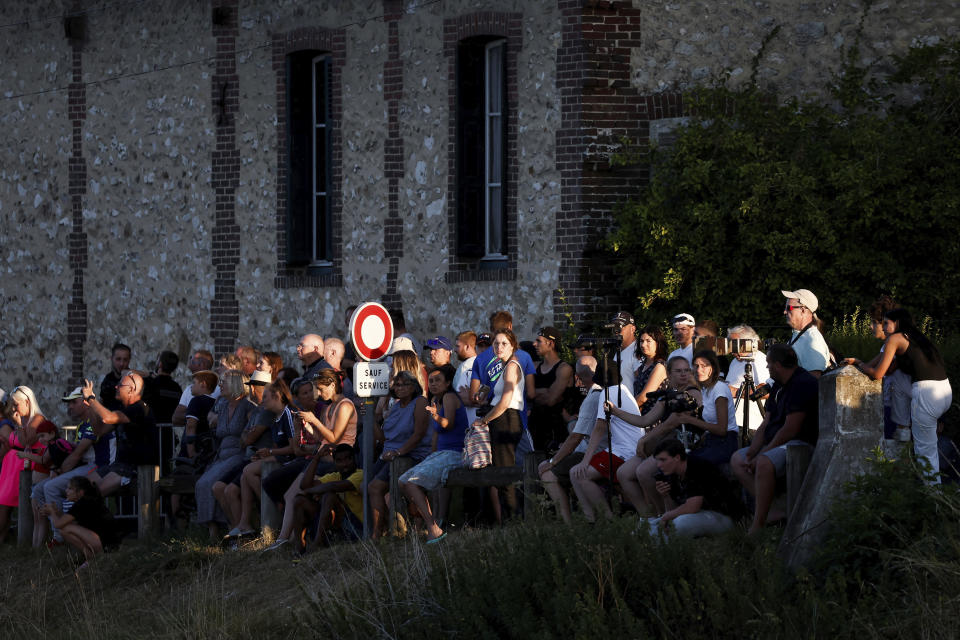 People and media gather to see firefighters and members of a search and rescue team conduct a mission to move a Beluga whale that strayed into France's Seine river to a saltwater basin, near the Notre-Dame-de-la-Garenne lock in Saint-Pierre-la-Garenne, west of Paris, France, Tuesday, Aug. 9, 2022. (Benoit Tessier / Pool via AP)