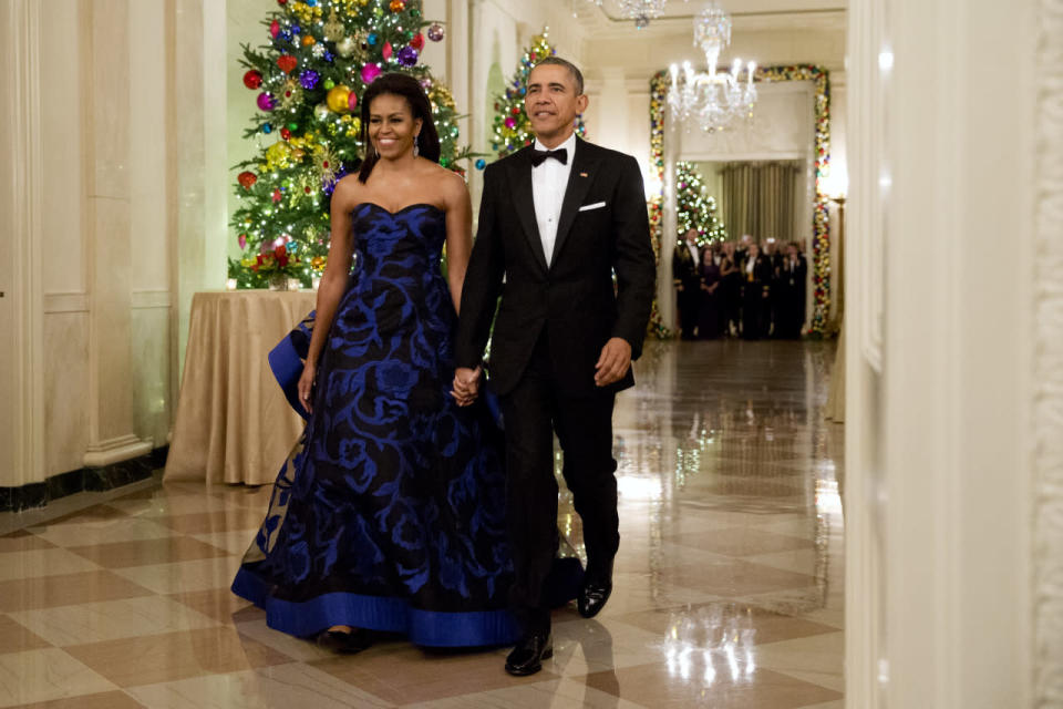 First Lady Michelle Obama in a blue and black gown with President Barack Obama at the 38th Annual Kennedy Center Honors at The Kennedy Center Hall of States in Washington, DC.