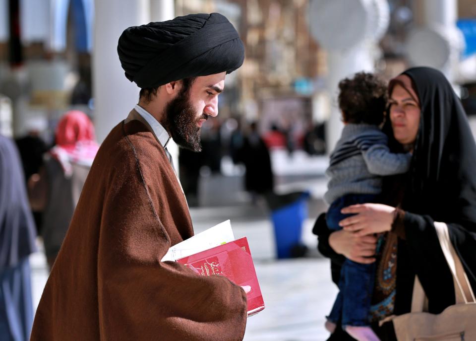 In this Sunday, Feb. 2, 2020 photo, a Shiite seminary student, left, walks to a class at "Hawza" seminary school, at the holy shrine of Imam Ali, the son-in-law, and cousin of the Prophet Muhammad and the first Imam of the Shiites, in Najaf, Iraq. Grand Ayatollah Ali al-Sistani, Iraq’s top Shiite cleric, turns 90 this year, and when he recently had surgery it sent chills around the country and beyond. What happens when al-Sistani is gone? Iran is likely to try to exploit the void to gain followers among Iraq’s Shiites. Standing in its way is the Hawza, the centuries-old institution of religious learning which al-Sistani heads and which follows its own tradition-bound rules. (AP Photo/Hadi Mizban)