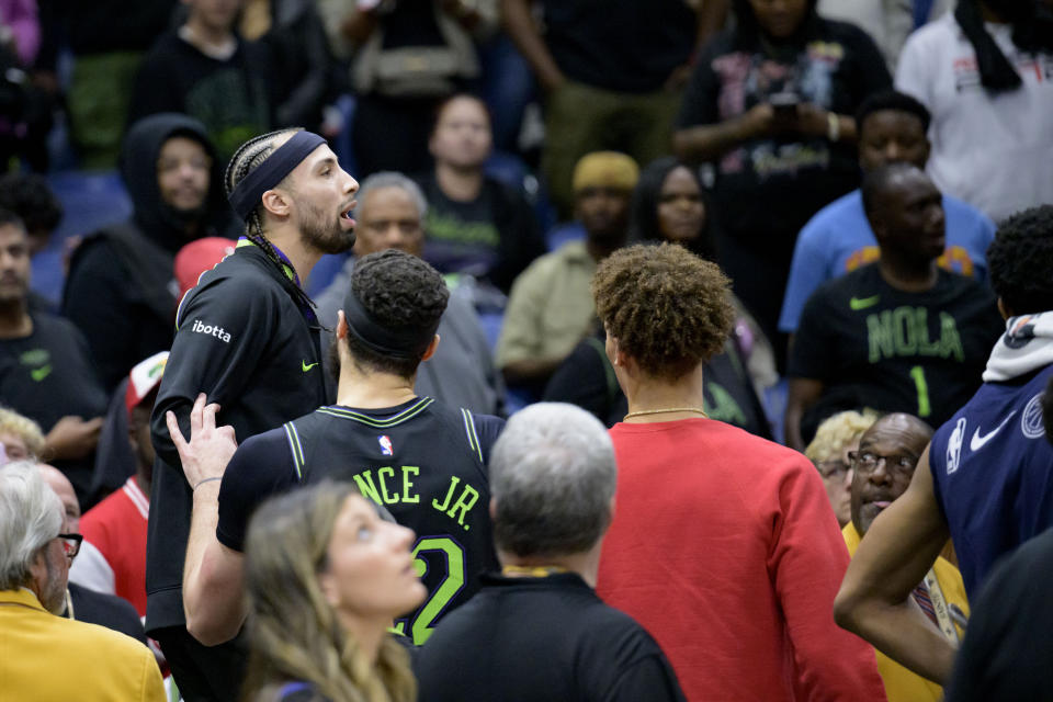 New Orleans Pelicans guard Jose Alvarado, upper left, climbs on a chair and is surrounded by teammates after a scuffle with Miami Heat center Thomas Bryant (not shown) during the second half of an NBA basketball game in New Orleans, Friday, Feb. 23, 2024. Alvarado and Bryant were ejected from the game. (AP Photo/Matthew Hinton)