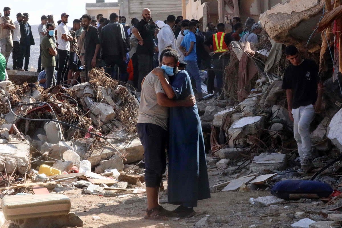 Two men comfort each other in the devastated Libyan city of Derna (Abdullah Doma/AFP via Getty Images)