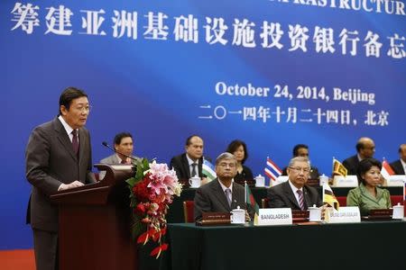 China's Finance Minister Lou Jiwei (L) gives a speech, with the guests of the signing ceremony of the Asian Infrastructure Investment Bank at the Great Hall of the People in Beijing October 24, 2014. REUTERS/Takaki Yajima/Pool