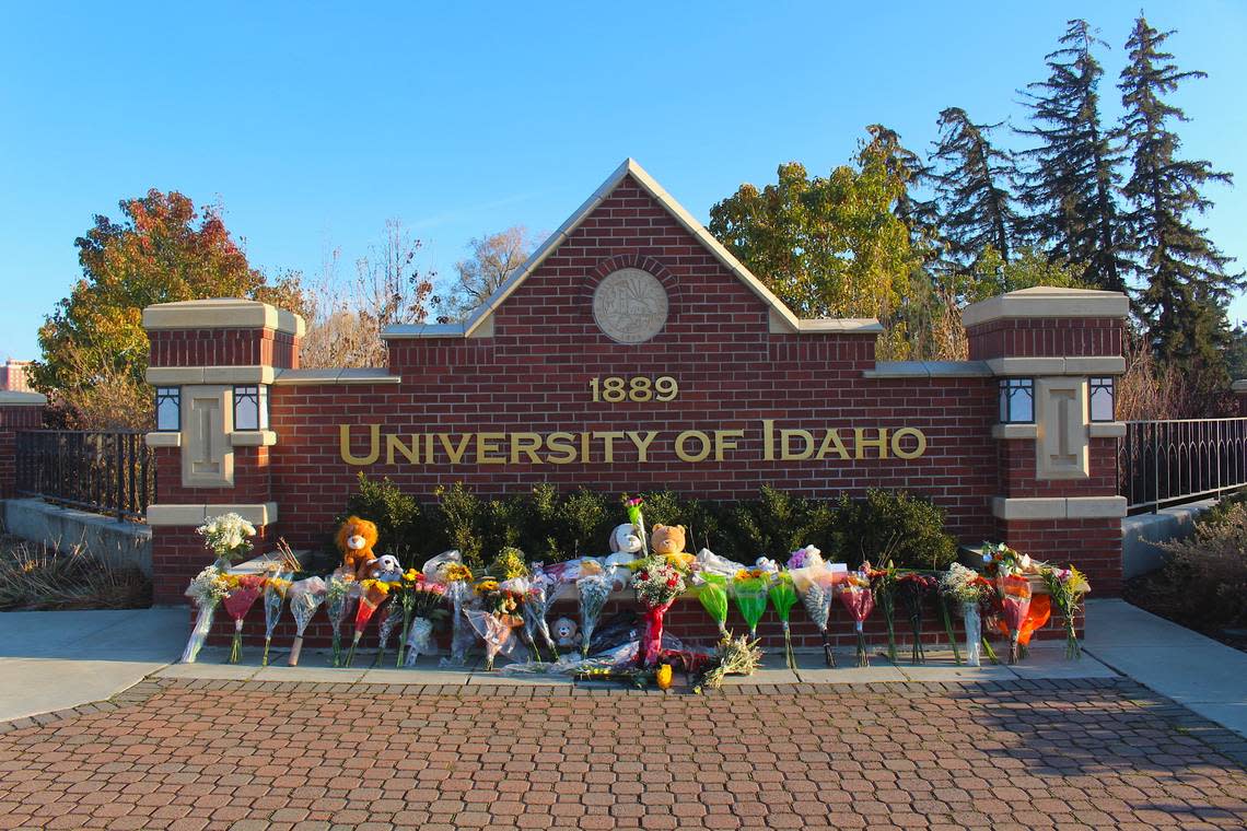 Flowers and stuffed animals are lined up outside a sign along Pullman Road in Moscow on Tuesday to pay tribute to four students who were killed in a gruesome attack early Sunday morning at a house near campus.