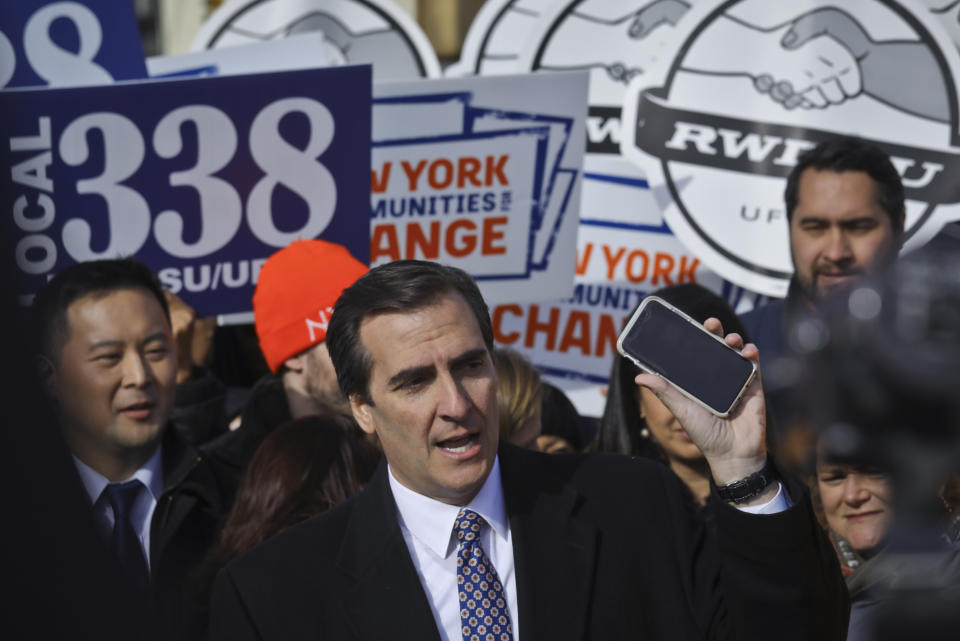 FILE - In this Nov. 14, 2018 file photo, New York State Sen. Michael Gianaris, center, calls on supporters to remove the Amazon app from their phones and boycott the company, as he address a coalition rally and press conference in New York. The first clue that opposition to the project could succeed in derailing the deal came in early February, when Gianaris was appointed to a seat on a state panel that often has to approve state funding for big economic development projects. According to the rules governing the 5-member Public Authorities Control Board, funds for any individual project can be vetoed by a single member, meaning that if the Amazon deal went before the board, Gianaris could kill it unilaterally. (AP Photo/Bebeto Matthews, File)