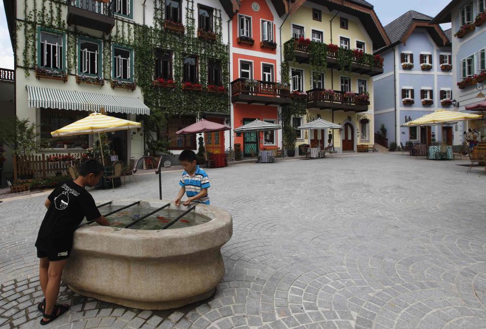 Children play with water in the area of the replica of Austria's UNESCO heritage site, Hallstatt village, of Huizhou