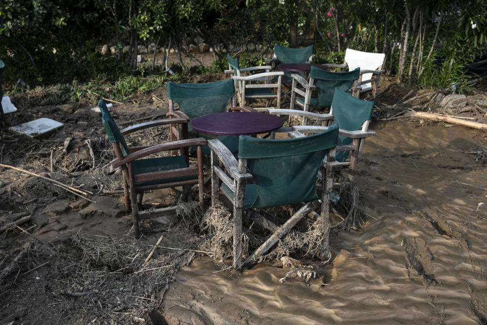 Mud and debris cover the area of a seaside coffee shop following a storm at the village of Bourtzi, on Evia island, northeast of Athens, on Sunday, Aug. 9, 2020. Five people, including en elderly couple and an 8-month-old baby have been found dead, two more are missing and dozens have been trapped in their homes and cars as a storm hits the island of Evia in central Greece, authorities said Sunday. (AP Photo/Yorgos Karahalis)