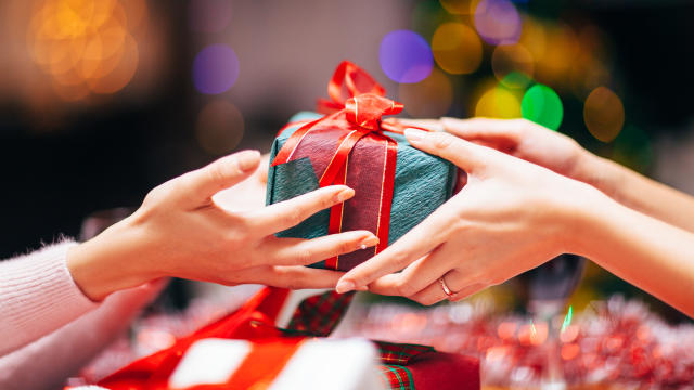 Close-up photography of two hands while giving gift.