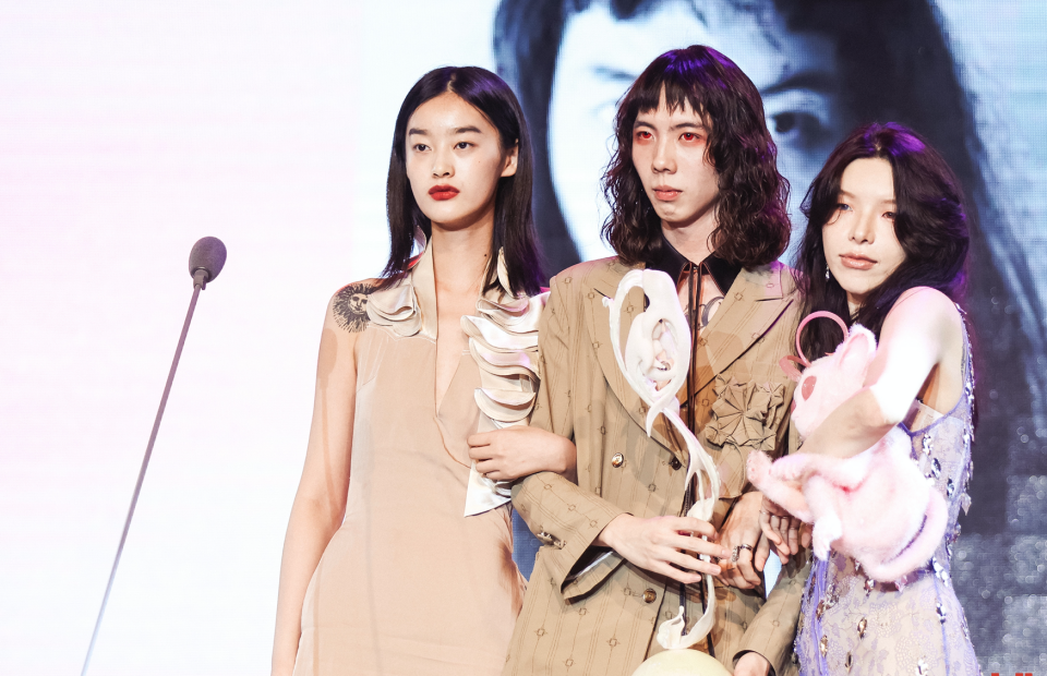 Louis Shengtao Chen, center, accepts his award with two models dressed in his looks. - Credit: Courtesy