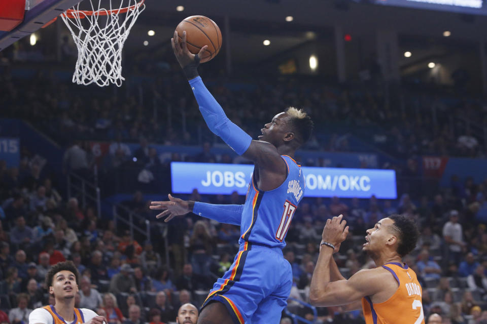 Oklahoma City Thunder guard Dennis Schroeder (17) shoots in front of Phoenix Suns forward Elie Okobo, right, during the first half of an NBA basketball game Friday, Dec. 20, 2019, in Oklahoma City. (AP Photo/Sue Ogrocki)