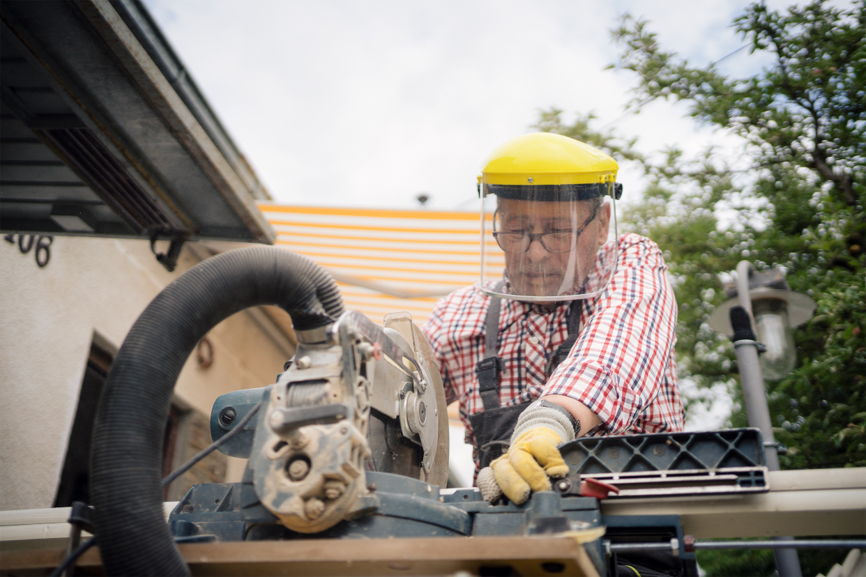 senior man using power tools outside