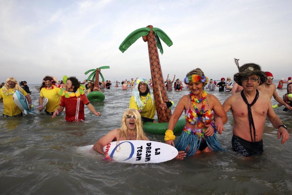 People wearing costumes participate in a traditional New Year's Day swim in Malo-les-Bains