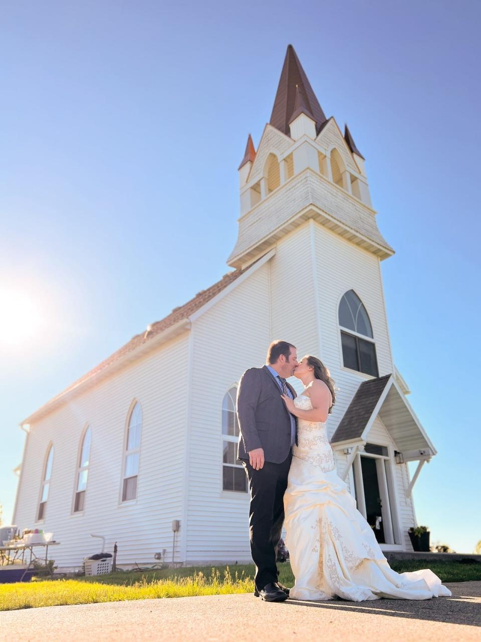 O'Mara and Adam Dunnigan in wedding attire outside a chapel they own in Detroit Lakes, Minnesota.