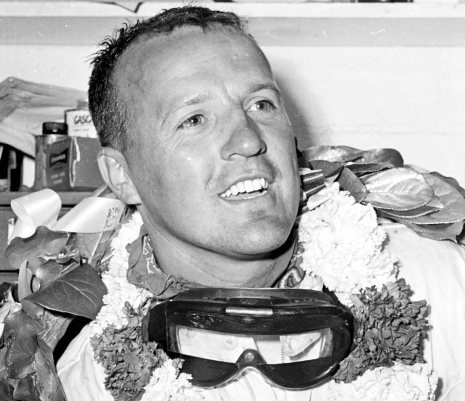 FILE - In this May 30, 1961, file photo, A.J. Foyt, still wearing his goggles and victory wreath, smiles in the garage area after winning the Indianapolis 500 auto race at Indianapolis Motor Speedway in Indianapolis, Ind. Tony Stewart had one favorite driver growing up and if he ever reached the same levels as A.J. Foyt, he hoped to emulate his hero. On the 60th anniversary of the first of Foyt's four Indianapolis 500 victories, Stewart will sit side-by-side next to his idol on the pit stand as Foyt's guest for the celebration. (AP Photo/File)