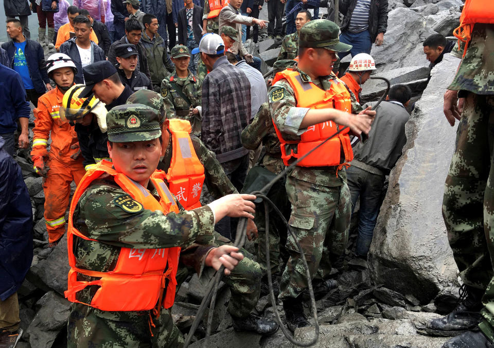 <p>Rescue workers work at the site of a landslide that destroyed some 40 households, where more than 100 people are feared to be buried, according to local media reports, in Xinmo Village, China, June 24, 2017. (Photo: Stringer/Reuters) </p>