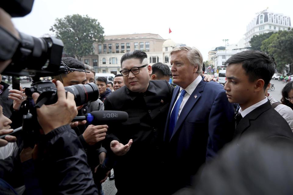 U.S. President Donald Trump impersonator Russell White, center right, and North Korean leader Kim Jong-un impersonator Howard X pose for photos outside the Opera House in Hanoi, Vietnam, Friday, Feb. 22, 2019. The second summit between Trump and Kim will take place in Hanoi on Feb. 27 and 28. (AP Photo/Minh Hoang)