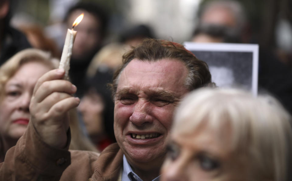 A man cries as he holds up a candle on the 25th anniversary of the bombing of the AMIA Jewish center that killed 85 people in Buenos Aires, Argentina, Thursday, July 18, 2019. (AP Photo/Natacha Pisarenko)