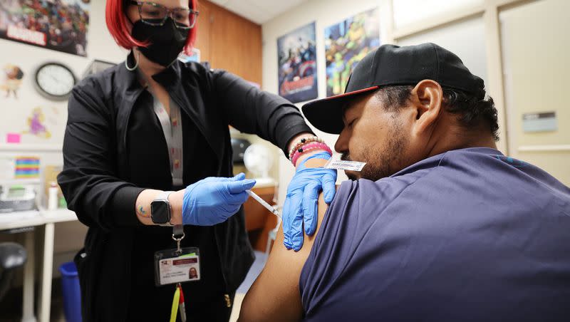 Hugo Varguez receives his COVID-19 vaccine from registered nurse Leila Callaway at Salt Lake County Health Center in Salt Lake City on Wednesday, Oct. 4, 2023.