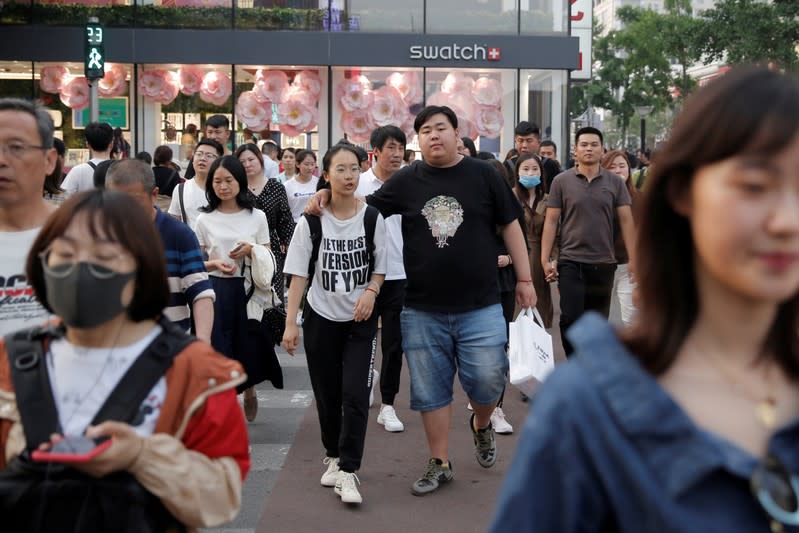 FILE PHOTO: People walk in Wangfujing shopping street in Beijing