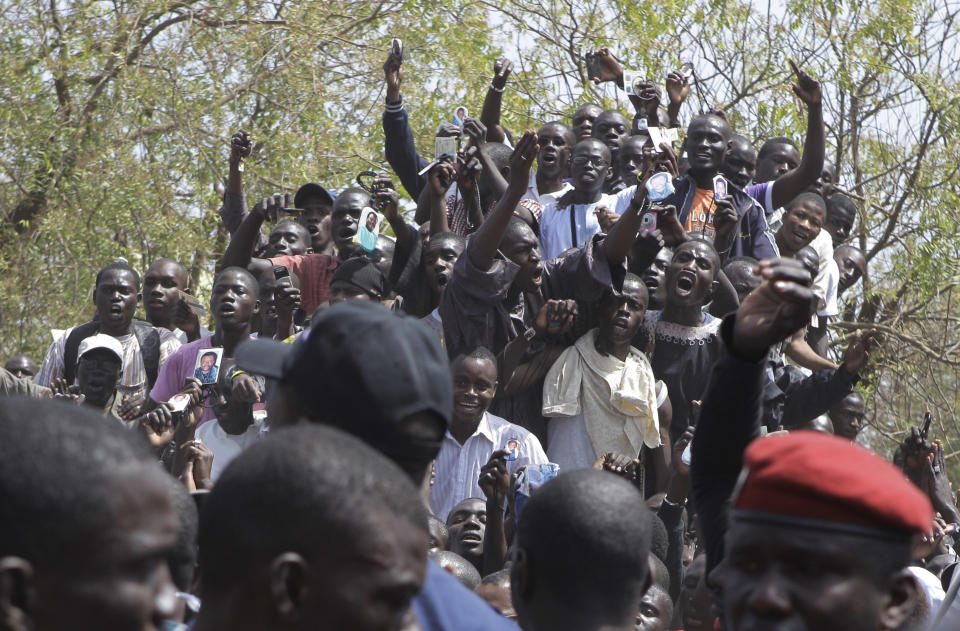 Supporters of Senegalese President Abdoulaye Wade, unseen, cheer outside the polling station where he was voting, in his home Point E neighborhood of Dakar, Senegal Sunday, March 25, 2012. Senegalese voters are deciding Sunday whether to give their 85-year-old president another term in office, or instead back his one-time protege Macky Sall in a runoff election that could oust the incumbent of 12 years.(AP Photo/Rebecca Blackwell)