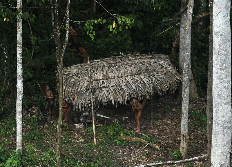 FILE PHOTO: Uncontacted indigenous react to a plane flying over their community in the Amazon basin