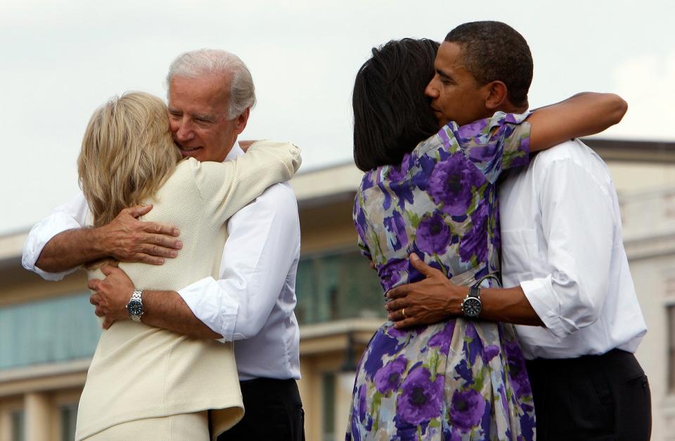 Joe Biden and Barack Obama embrace their wives after a rally to introduce Biden as Obama's vice-presidential running mate, 2008.