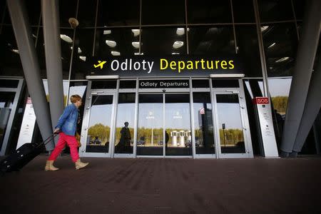 A woman walks outside the main entrance to the departure hall at the airport in Lodz October 10, 2014. REUTERS/Kacper Pempel