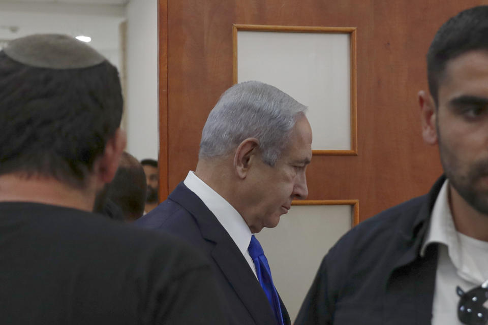 Israeli Prime Minister Benjamin Netanyahu, center, arrives at the District Court in Jerusalem, Israel, Sunday, June 25, 2023. Hollywood producer Arnon Milchan was testifying Sunday at Netanyahu’s corruption trial to answer questions about an alleged “supply line” of champagne and cigars funneled to the Israeli leader and his wife said to have been in exchange for help with Milchan’s personal and business needs. Milchan appeared by videoconference from the English city of Brighton. (Atef Safadi/Pool Photo via AP)