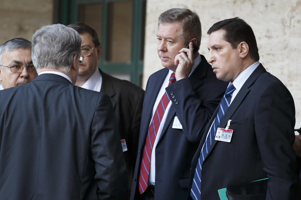 Russian deputy Foreign Minister Gennady Gatilov, 2nd right, makes a phone call after a meeting with the UN Joint Special Representative for Syria Lakhdar Brahimi, the second round of negotiation between the Syrian government and the opposition in Geneva, Switzerland, Wednesday , Feb. 12, 2014. (AP Photo/Keystone,Salvatore Di Nolfi)