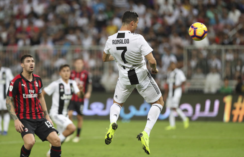 Juventus' Cristiano Ronaldo, right, scores his side's opening goal during of the Italian Super Cup final soccer match between AC Milan and Juventus at King Abdullah stadium in Jiddah, Saudi Arabia, Wednesday, Jan. 16, 2019. (AP Photo)