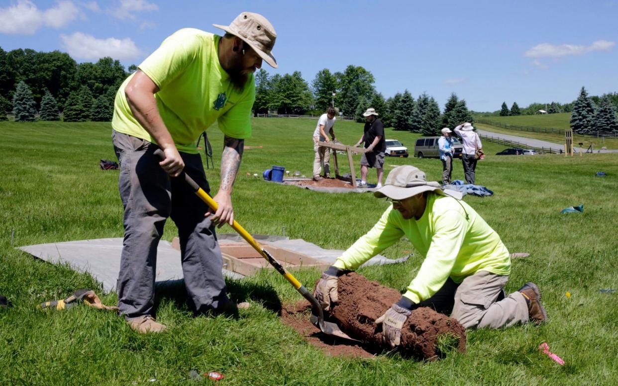 Jesse Pagels, left, and Edgar Alarcon, of the Public Archaeology Facility at Binghamton University start a new dig at the site of the original Woodstock Music and Art Fair, in Bethel, New York - AP