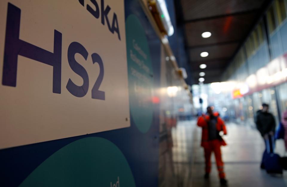 Workers walk past a sign outide a construction site for a section of Britain's HS2 high-speed two railway project, at London Euston train station in London on January 20, 2020. - Britain's government on Monday said it would shortly decide on whether to proceed with its HS2 high-speed two railway project, whose cost is reportedly set to soar to more than £100 billion. HS2, which will quicken rail journeys between London in southeast England and cities to the north of the capital, has been dogged by controversy owing to projected spiralling costs and damage to wildlife. (Photo by Tolga AKMEN / AFP) (Photo by TOLGA AKMEN/AFP via Getty Images)