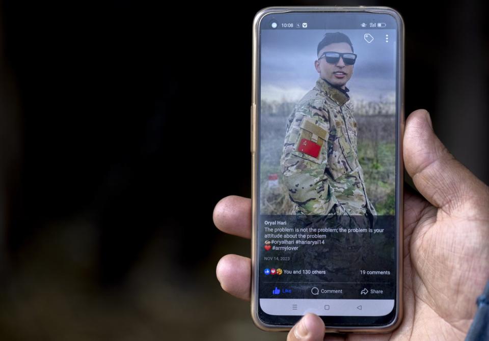 Raju Aryal shows a Facebook post by his late brother, Hari Aryal, wearing a Russian uniform (EPA)