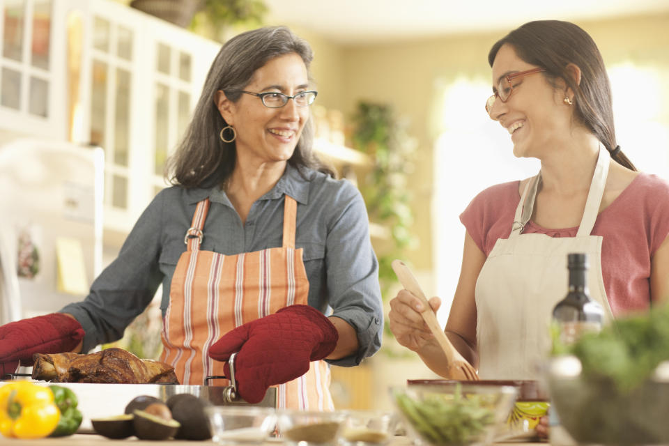 Mother and daughter cooking in domestic kitchen